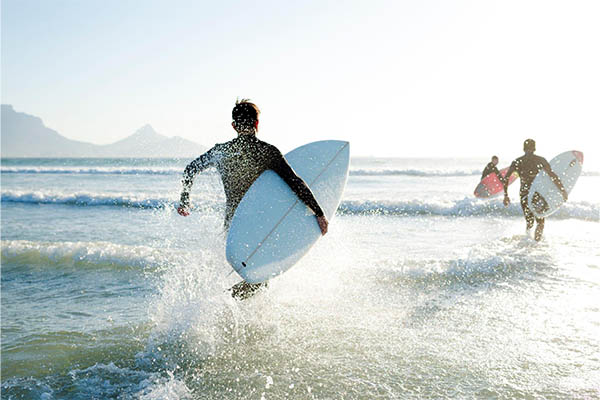 pessoa segurando uma prancha indo surfar na praia brava em itajaí